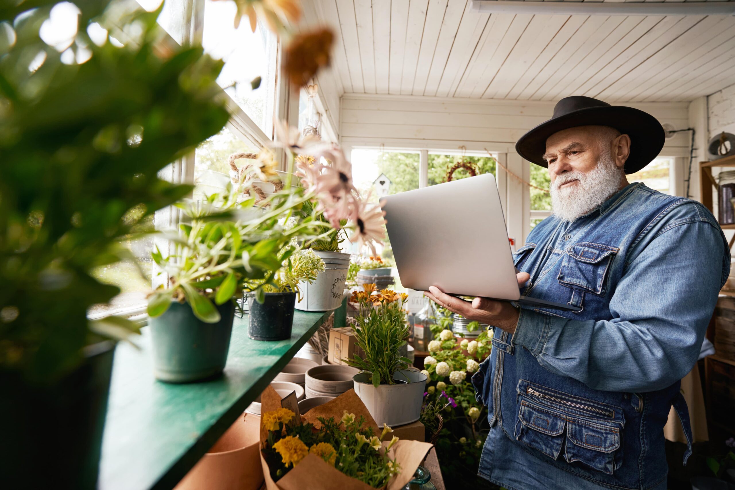 senior-bearded-florist-with-laptop-at-work-2022-09-01-02-42-42-utc-min