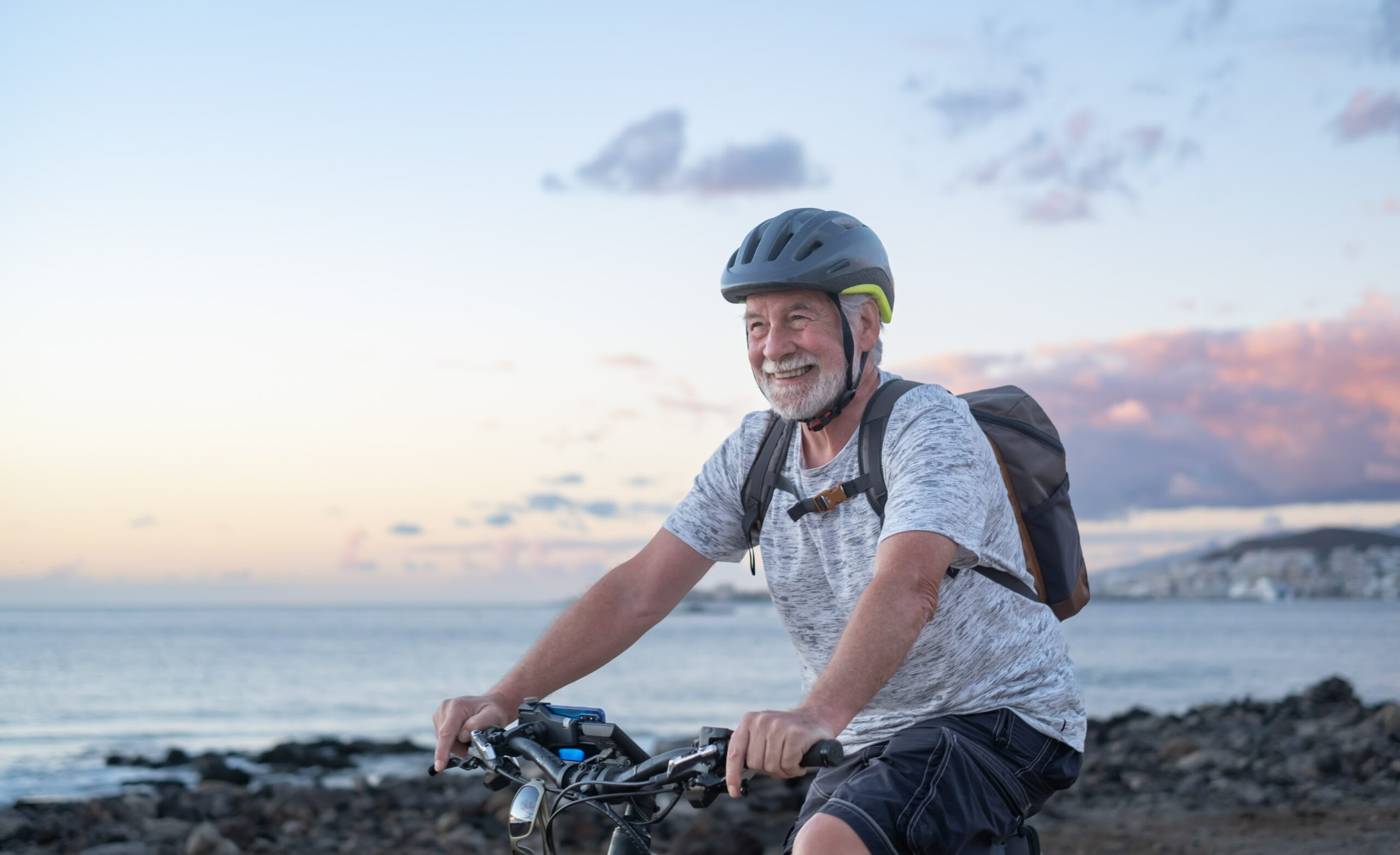 happy-senior-cyclist-man-at-the-beach-at-sunset-en-2021-12-09-08-28-54-utc-min