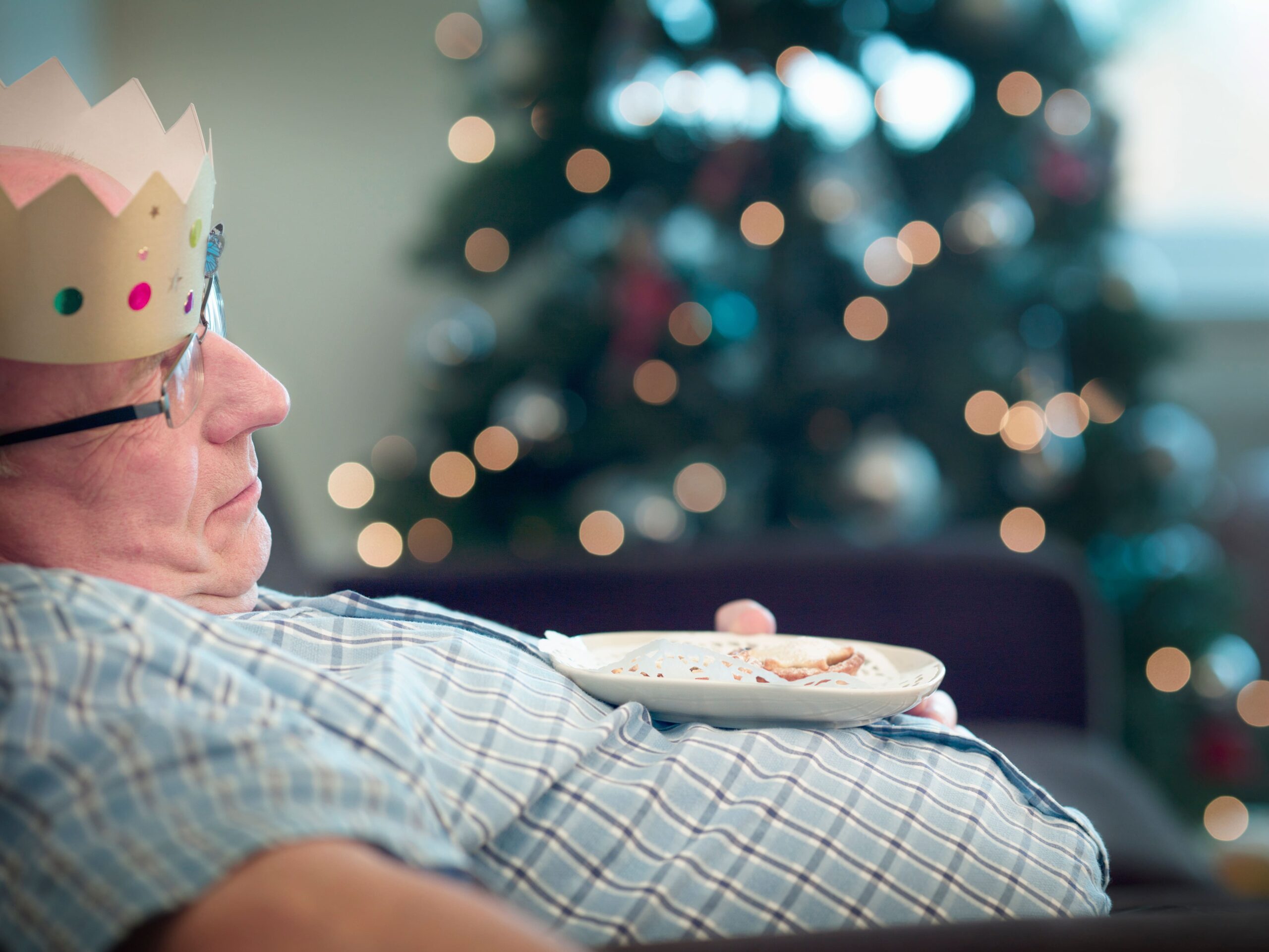 senior-man-wearing-party-hat-asleep-2023-11-27-05-05-43-utc-min