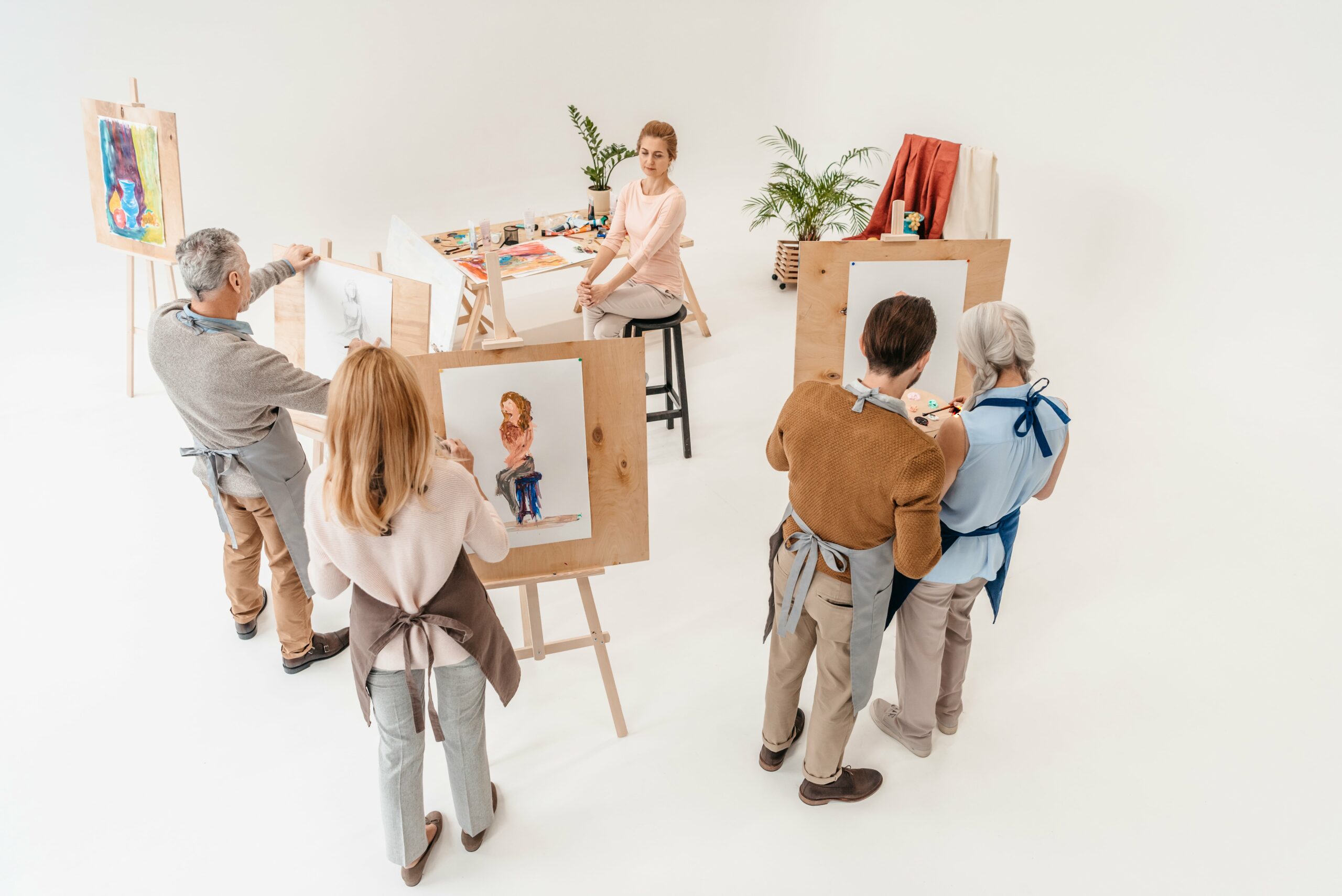 high-angle-view-of-senior-people-painting-on-easel-2023-11-27-04-52-23-utc-min