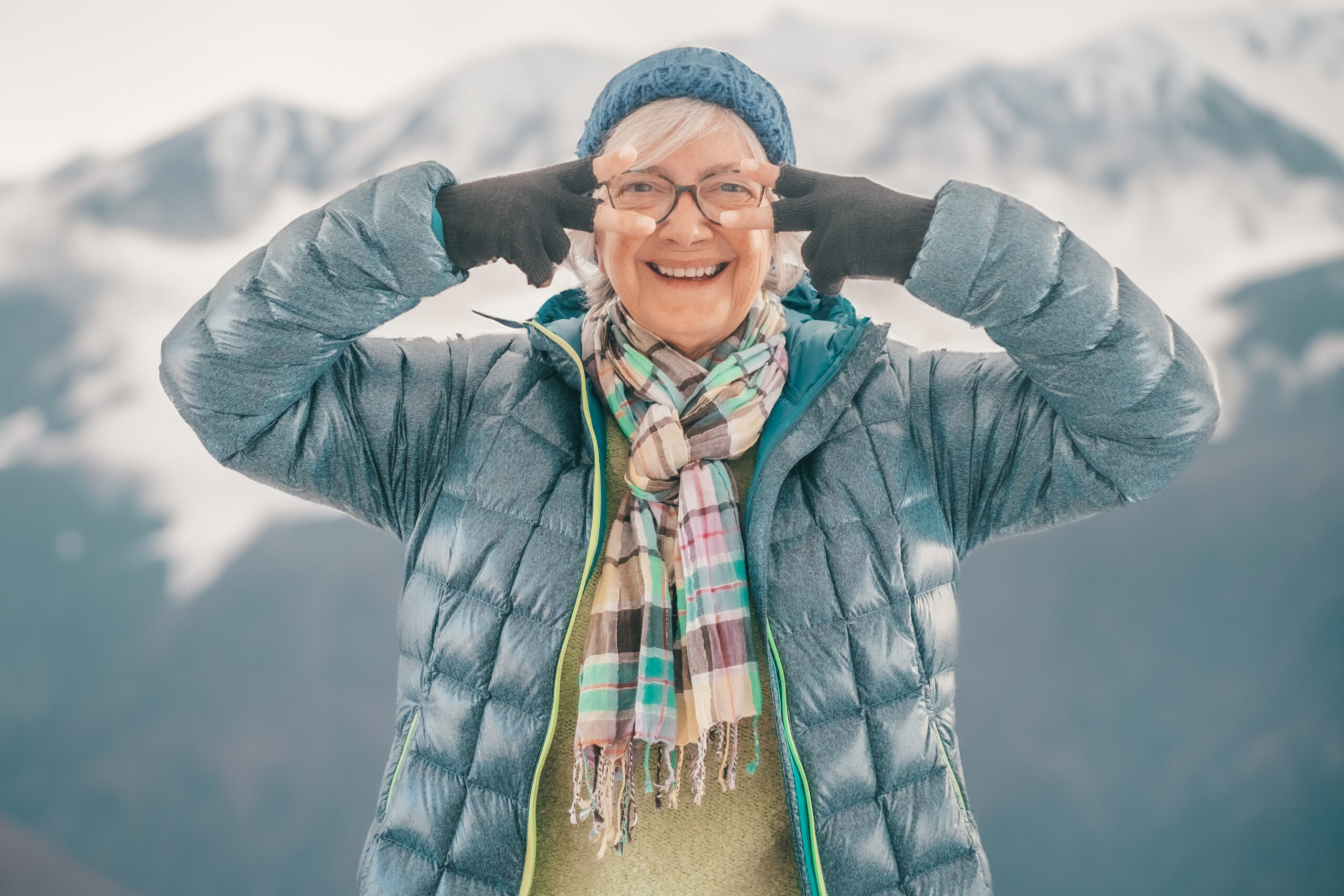 Joyful senior woman in outdoors in winter time looking at camera