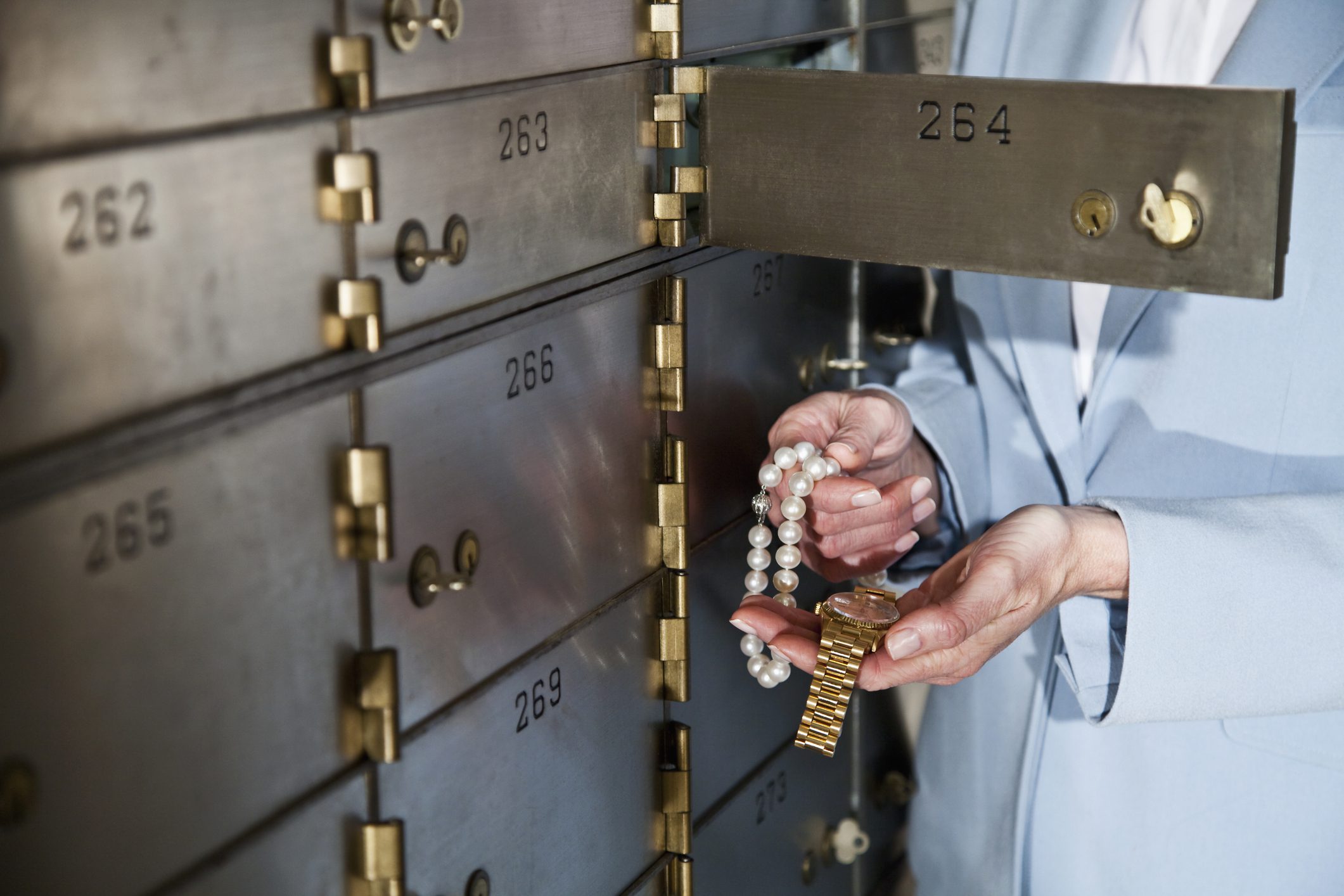 Woman putting jewelry in safety deposit box
